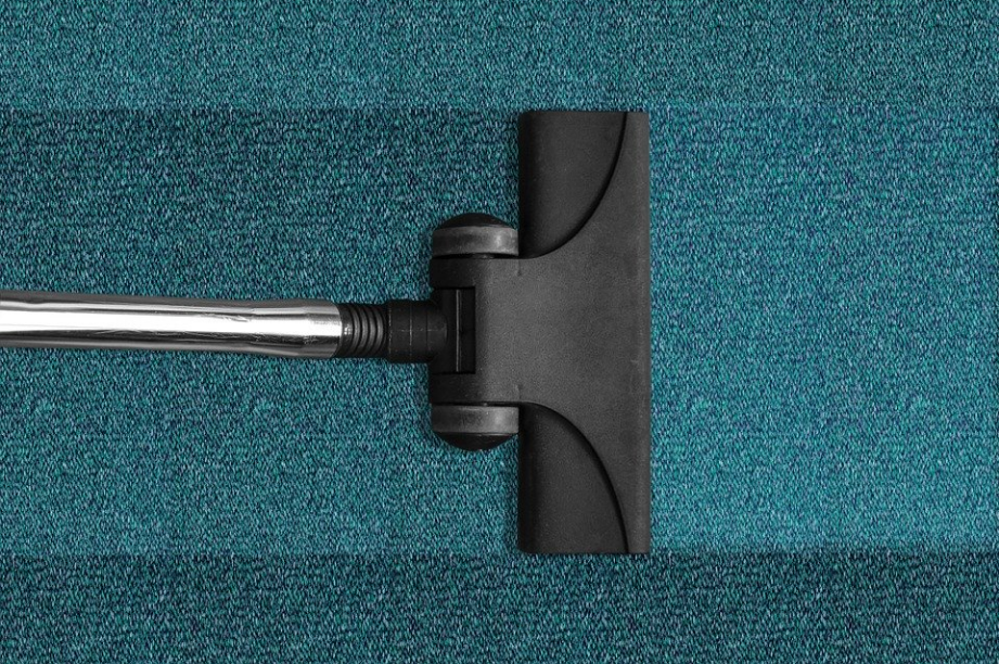 a vacuum cleaner cleaning blue carpet